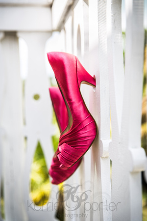 Bright shoes hanging from white balcony railing.