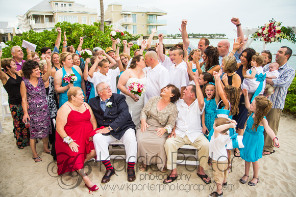 A large group of guests cheer for the newlyweds at a beach ceremony at Pier House Resort in Key West.