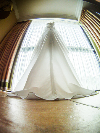 A bride's dress hangs elegantly in the window of her Pier House Resort suite