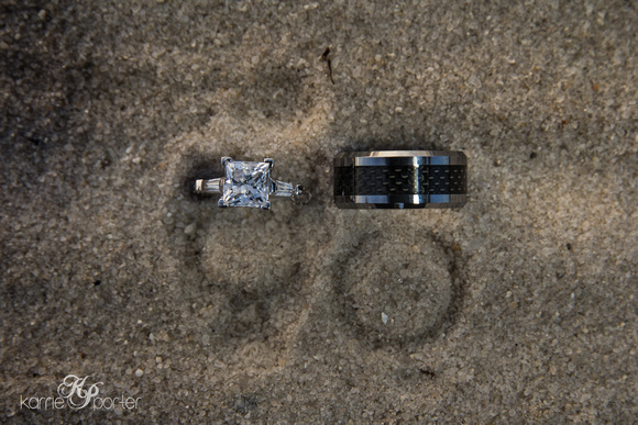 Wedding rings in beach with impressions left in the sand