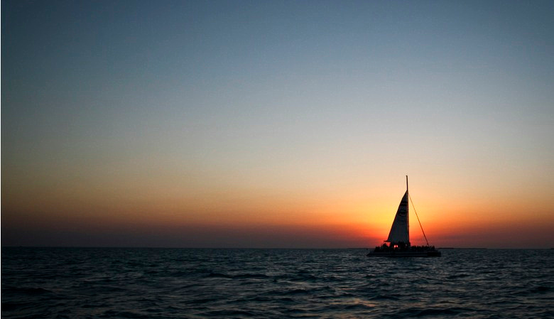 Fury Catamarans sails across the sunset in Key West, Florida.  Bond Fire Studio.