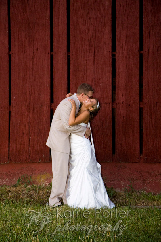 country wedding bride and groom by red barn