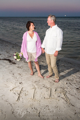 Bride and groom enjoy a casual ceremony on the beach of Key West, with their wedding date written in the sand.